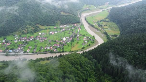 Malá vesnice s krásnou krajinou, Horská krajina s tradiční venkovskou komunitou s mraky a mlhou za úsvitu. Pěstování plodin a zemědělství. 4k Aerial Drone shot — Stock video