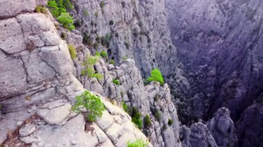 Muazzam Muhteşem Kayalar, ünlü kanyon üzerinde destansı hava aracı uçuşu, Dağlar Vadisi, devasa taş yapılar, yeşil ağaçlı dramatik jeolojik harikalar. Kuş bakışı manzara 4k