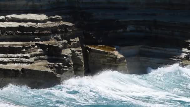 Olas rompiendo sobre rocas peligrosas, concepto de tormenta marina, paisaje marino diurno soleado, devastador y espectacular, olas oceánicas chocan contra las rocas de la costa creando una explosión de agua, 4k — Vídeos de Stock