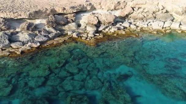 空中トップビュー海の青い水と岩の無人機による4k映像,穏やかな海は岩の山を洗います,世界のエッジと青い海のビーチ,劇的な地質学的不思議,美しい風景 — ストック動画