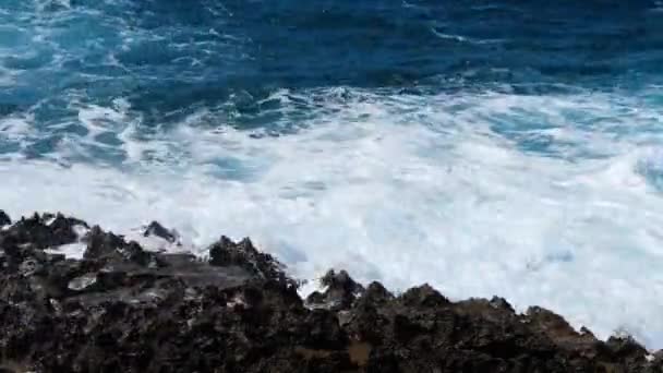 Olas rompiendo sobre rocas peligrosas, concepto de tormenta marina, paisaje marino diurno soleado, devastador y espectacular, olas oceánicas chocan contra las rocas de la costa creando una explosión de agua, 4k — Vídeo de stock