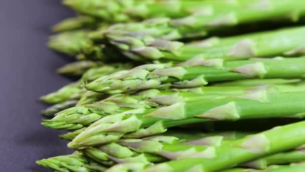 アスパラガス,新鮮な有機緑のアスパラガスの芽を閉じます,健康的な菜食主義者の食べ物.生野菜、市場。ビーガンの背景。スローモーション4K UHDビデオ — ストック動画