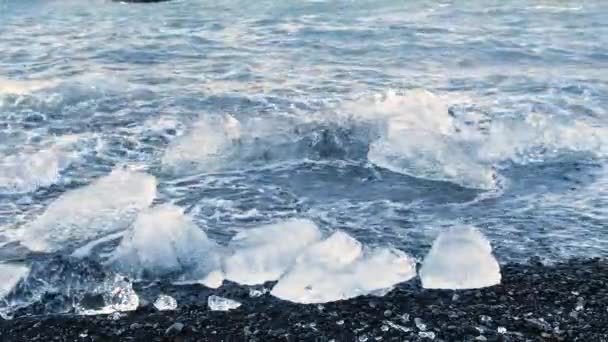 Trozos de hielo sobre arena negra, Concepto de Cambio Climático por el Calentamiento Global, Icebergs en Laguna Glaciar Jokulsarlon, Islandia — Vídeos de Stock