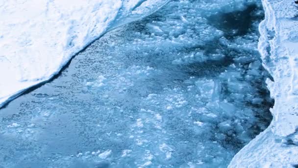 Rio congelado, inverno frio ou paisagem de primavera, Um rio congelado com uma enorme corrente, Fragmentos de gelo flutuando rio abaixo. Água cristalina e gelo, um rio glacial em fusão na Islândia — Vídeo de Stock