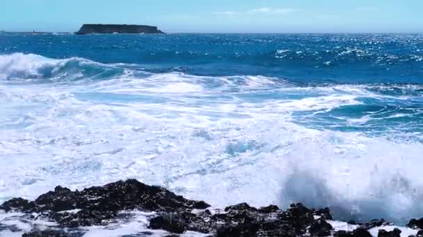 Concepto de tormenta de mar 4k, imágenes del paisaje de agua azul océano y rocas, paisaje marino diurno soleado, devastador y espectacular, las olas del océano se estrellan en las rocas de la costa creando una explosión de agua — Vídeo de stock