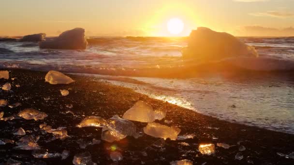 Diamond strand in IJsland, brokken ijs op zwart zand bij zonsopgang, Kristalhelder water en een prachtig natuurlijk wonder, Global Warming en Climate Change Concept, IJsbergen in Jokulsarlon Gletsjer Lagune — Stockvideo