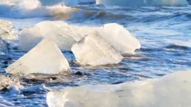 Kara kumdaki buz kütleleri, Küresel Isınma, İklim Değişikliği Konsepti, Jokulsarlon Buzul Gölü 'ndeki buz dağları, İzlanda' daki elmas plajı.