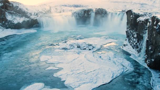 Годафосс, знаменитый водопад в Исландии, Замороженный водопад зимой, волшебное зимнее расположение снега и льда, чистая ледниковая вода с огромным течением — стоковое видео