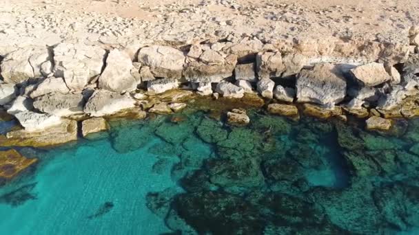 Aerial landscape at the edge of the earth, Turquoise calm sea waves beat against a rocky cliff, Ocean breeze, purity and untouched nature, Geological wonder, Cyprus — Video Stock