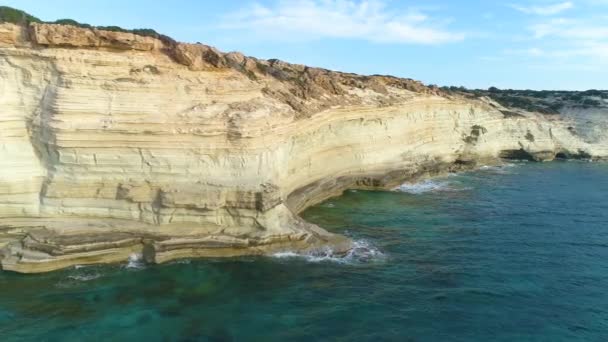 Paisaje aéreo en el borde de la tierra, Turquesa olas marinas tranquilas golpean contra un acantilado rocoso, Brisa del océano, pureza y naturaleza intacta, Maravilla geológica, Chipre — Vídeos de Stock