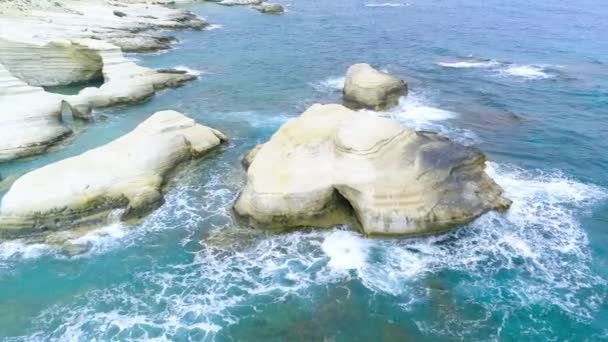 Oceano litoral a partir de uma visão de aves-olho, ondas azuis do mar lavar a costa rochosa na bela praia vista aérea drone 4k tiro, água azul-turquesa clara e rochas brancas. Chipre — Vídeo de Stock