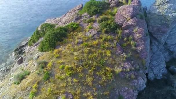 Vzdušný výhled na útesy v tyrkysové vodě za slunečného dne. Oceánské vlny na krásném pobřeží. Moře naráží na Osamělé horské skály, Turistická destinace na Kypru — Stock video