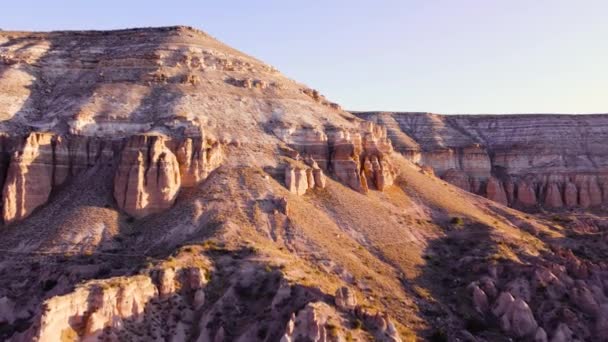 日没のカラフルな山脈の谷、赤とピンクの丘、岩の砂漠で劇的な地質学的不思議。空中の鳥の目のビュー、地質学的不思議カッパドキア、トルコのGulludere — ストック動画