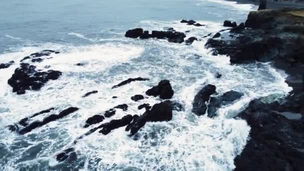 Costa do oceano na Islândia, ondas quebram em rochas, o mar corrói rochas vulcânicas, vista aérea — Vídeo de Stock