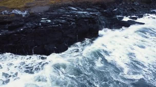 Olas rotas en rocas volcánicas negras en un océano azul, Tormenta en el mar Vista aérea, Islandia — Vídeos de Stock