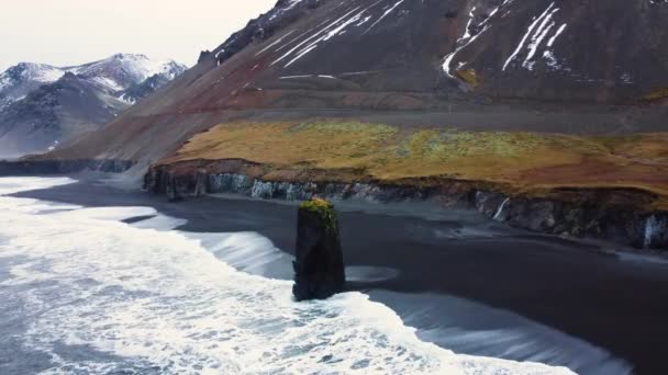 İzlanda 'daki okyanus kıyısında dalgalar kayalara çarpar, deniz volkanik kayaları aşındırır, hava manzarası... — Stok video