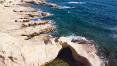 Okyanus üzerindeki doğa manzarası, olağandışı Rocky sahillerindeki deniz dalgaları, dalgalar beyaz uçurumları yıkıyor.