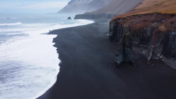 Vulkaniska landskap på Island, Havsvågor på svart sandstrand, Fåglar öga Flygfoto över havet vågor kraschar mot en tom sten klippa — Stockvideo