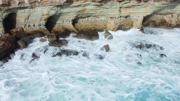 岩の多い海岸、嵐の間の地中海の海岸線、キプロスの空中風景に対する海洋波の衝突 — ストック動画