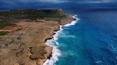 Blue Mediterranean denizi, Ocean Water during Storm, Bird Eye View 4K Cinematic Drone Video ile birlikte Rocky Coastside 'ın üzerinde uçuyor. Deniz kıyısının üzerinde Gökyüzünden, Kıbrıs