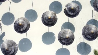 Deniz kenarında şemsiyeleri olan boş kumlu bir sahil, güneşli bir hava. Tatiller ve tatiller yazın cennet kıyısında, Aerial view, Kıbrıs