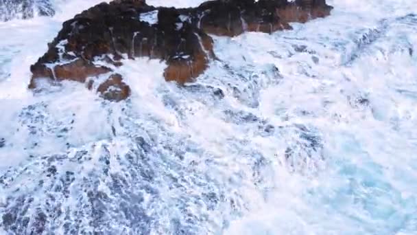 Luchtfoto van golven breken op rotsen in een blauwe oceaan, Zee golven op prachtig strand Vogels oog uitzicht op oceaan golven crashen tegen een lege stenen rots klif van boven, Cyprus — Stockvideo