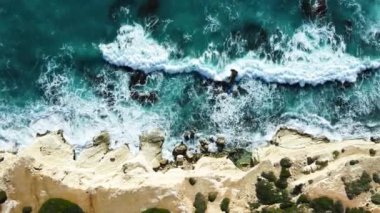 Kayalık Kıyı Hattı üzerinde Mavi Akdeniz ile birlikte Uçan Okyanus Suyu Gün Batımında Güneş 'e Doğru. Kuş Gözü Görünümü 4K Sinematik İnsansız Hava Aracı. Deniz kıyısının üzerinde Gökyüzünden, Kıbrıs.