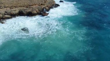 Kayalık Kıyı Hattı üzerinde Mavi Akdeniz ile birlikte Uçan Okyanus Suyu Gün Batımında Güneş 'e Doğru. Kuş Gözü Görünümü 4K Sinematik İnsansız Hava Aracı. Deniz kıyısının üzerinde Gökyüzünden, Kıbrıs.