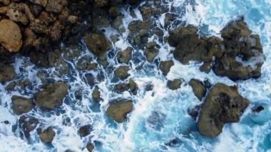 Sea washes the rocky shore, Above Aerial shot, Flying Over Coastline, Cliffside with Blue Pure Water, Ocean During Sunny weather. Bird Eye View 4K Cinematic Drone Footage. Coast From the Air, 