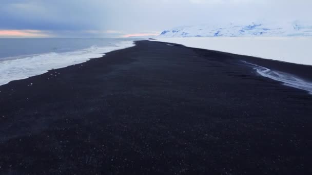 在冰天雪地的冬日 冰岛的黑色海滩上撒满了火山灰 是著名的地标 美丽的空中北极景观 高质量的4K镜头 — 图库视频影像