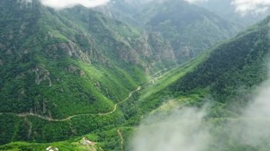 Dağ ormanlarının üzerinde bulutlar arasında uçmak, hava manzarası, harika ilham verici doğal yaz manzarası. Yüksek kalite 4k görüntü
