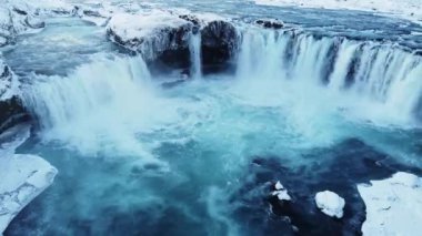 Buz gibi kış gününde Kuzey İzlanda 'da muazzam Godafoss şelalesinin muhteşem insansız hava aracı görüntüsü. Ünlü bir simge, dokunulmamış kutup manzarası. Yüksek kalite 4k görüntü