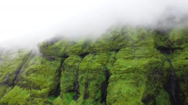 İzlanda 'daki yeşil volkanik dağlar yaz mevsiminde 4K' lık güzel bir hava çekimi..