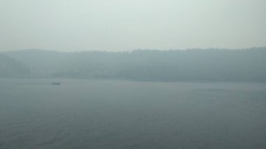 thick fog on the sea surface faintly visible fishing boats sailing