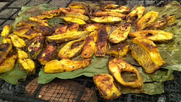 pieces of grilled carp meat with spices on banana leaves ready to eat