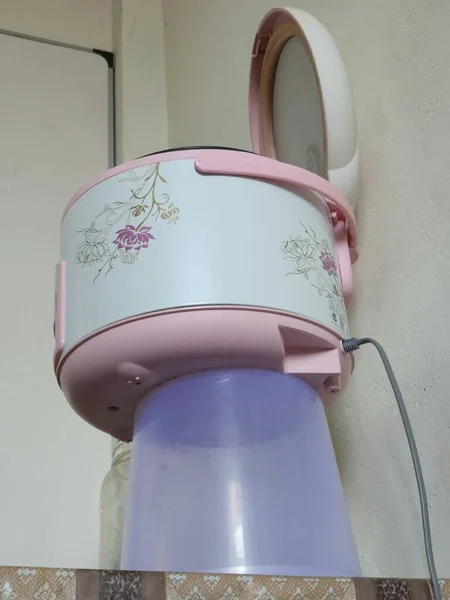Bottom view of the white and pink rice cooker with floral ornaments