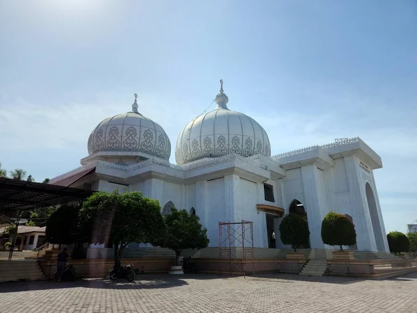 White mosque building with blue sky background under the sunlight