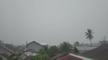 Thunderstorms and rain on the roofs of residential areas behind the glass 