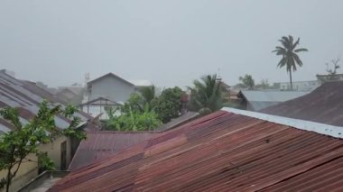 Storm winds and rain on the roofs of residential areas