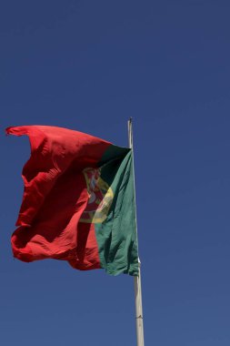 Portekiz Bayrağı. Yüksek kalite fotoğraf. Titreyen Portekiz bayrağı, mavi gökyüzüne karşı, güneşli bir günde..