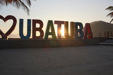 Renkli Ubatuba şehir isim plakası gün doğumunda Itagua sahilinde, Ubatuba, Brasil 'de. Yüksek kalite fotoğraf