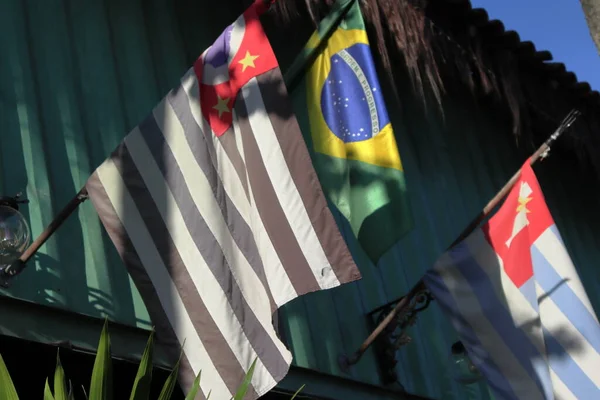 Sao Paulo, Brazil and Ubatuba flags inclined against miscelaneous background. High quality photo