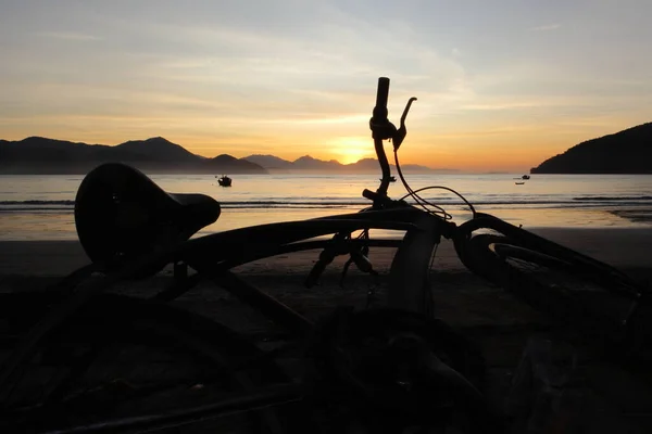 Bike silhouette against winter sunrise at Itagua beach, Ubatuba, Brazil. High quality photo