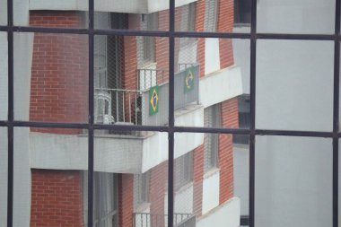 Sao Paulo, Brezilya, 19 Ekim 2022: Pencerelerinde Brezilya bayrakları bulunan bir yerleşim yeri.