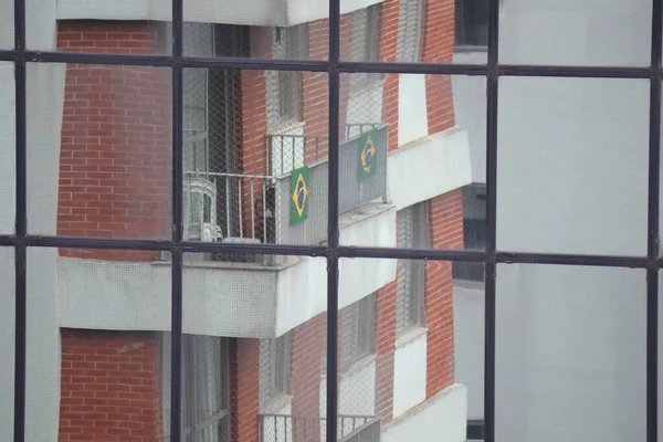 Sao Paulo, Brezilya, 19 Ekim 2022: Pencerelerinde Brezilya bayrakları bulunan bir yerleşim yeri.