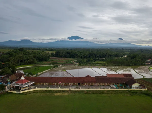 The building of an elementary school with a background of mountains and has a large field