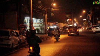 Malioboro Caddesi 'nde gece vakti sokak satıcısı ve ziyaretçilerinin durumu.