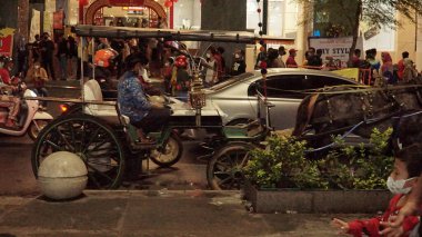Malioboro Caddesi 'nde gece vakti sokak satıcısı ve ziyaretçilerinin durumu.