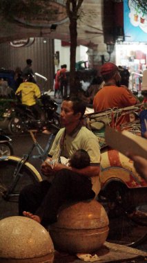 Malioboro Caddesi 'nde gece vakti sokak satıcısı ve ziyaretçilerinin durumu.