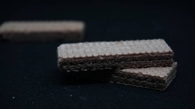 Siyah arka planda tatlı gofretler, düz yatış. Tatlı yemek. Arkaplan dokusu